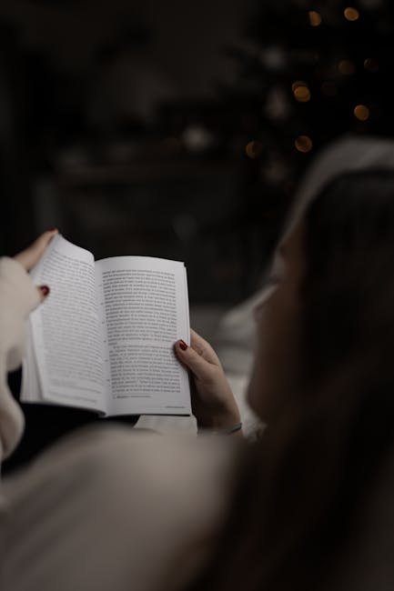 A person reads a book indoors, enveloped in warm, ambient lighting, creating a cozy atmosphere.